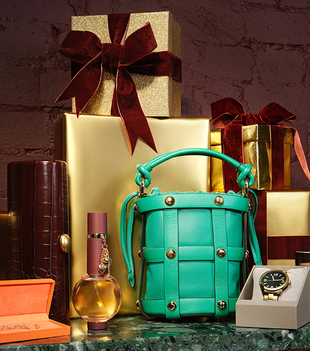 Turquoise handbag displayed among gift boxes, perfume, handbag, watch and other gifts.