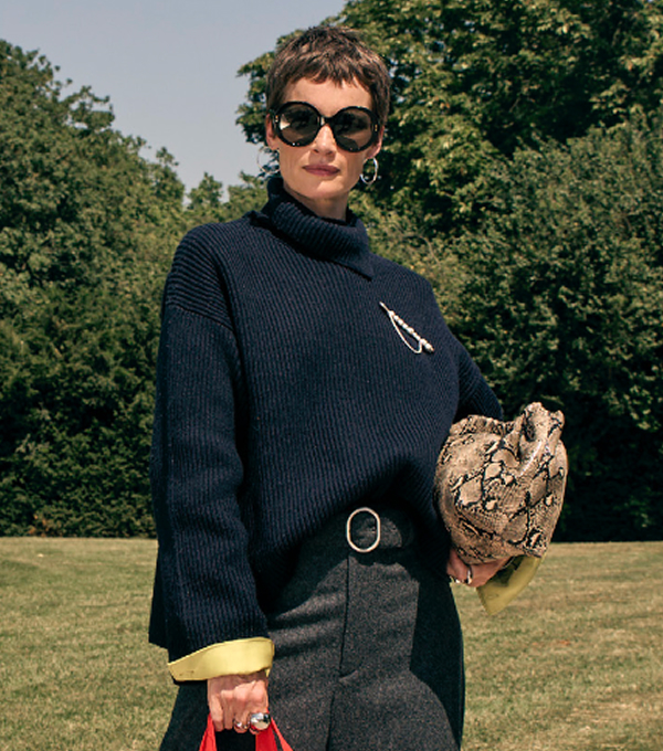Woman wearing knitted jumper and sunglasses.